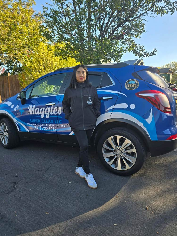 Jessica, owner of Maggie's Super Clean, standing beside the company vehicle
