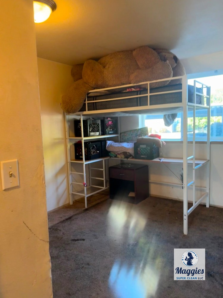 After: A bedroom area with bunk shelving, bedding, storage crates, and a large stuffed animal, reflecting the household belongings and floor space addressed during the residential cleanup project.