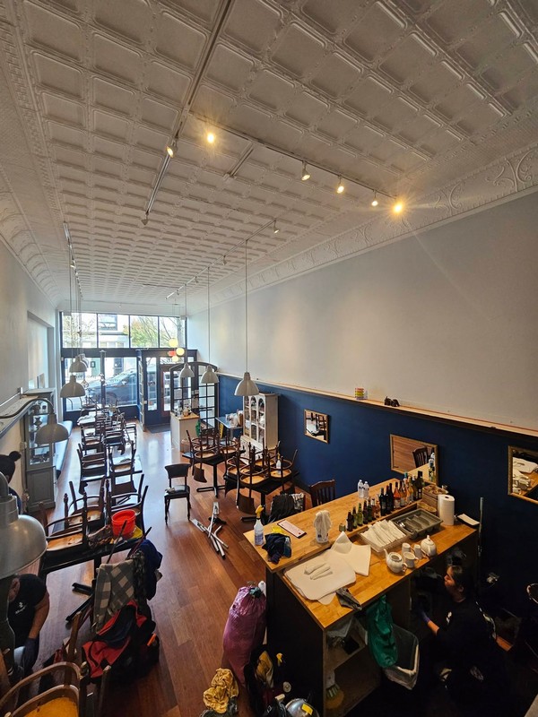 Wide view of the restaurant dining room during the annual deep clean, with tables and chairs moved to provide access to the floors and surrounding areas.