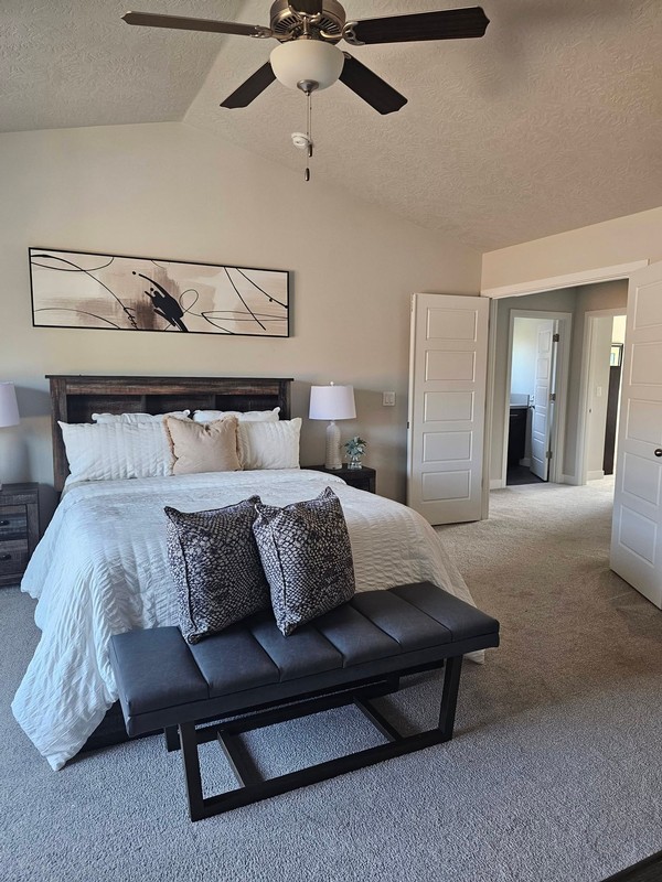 The bedroom presents a neat, refreshed appearance, with the bed, nightstands, ceiling fan, and surrounding surfaces arranged in a clean and comfortable space.