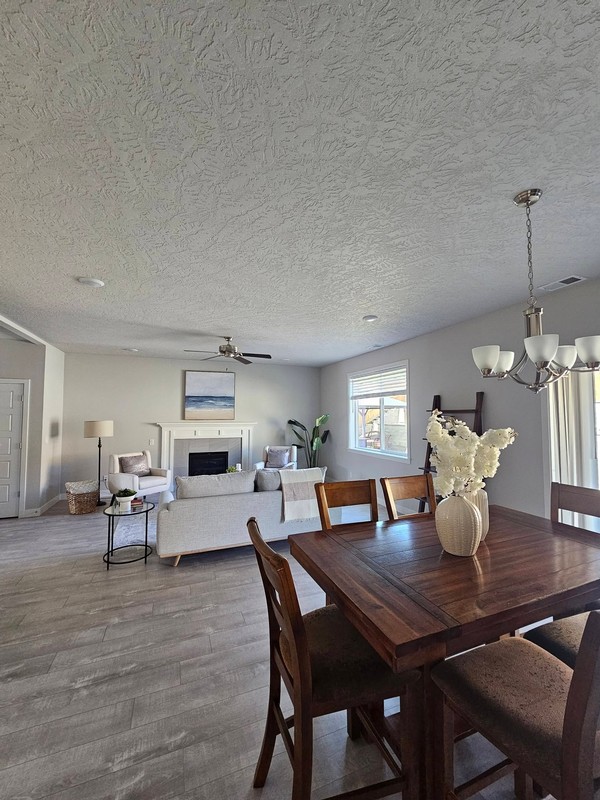 The open living and dining area has a clean, orderly presentation across the flooring, furniture, dining table, and surrounding surfaces.