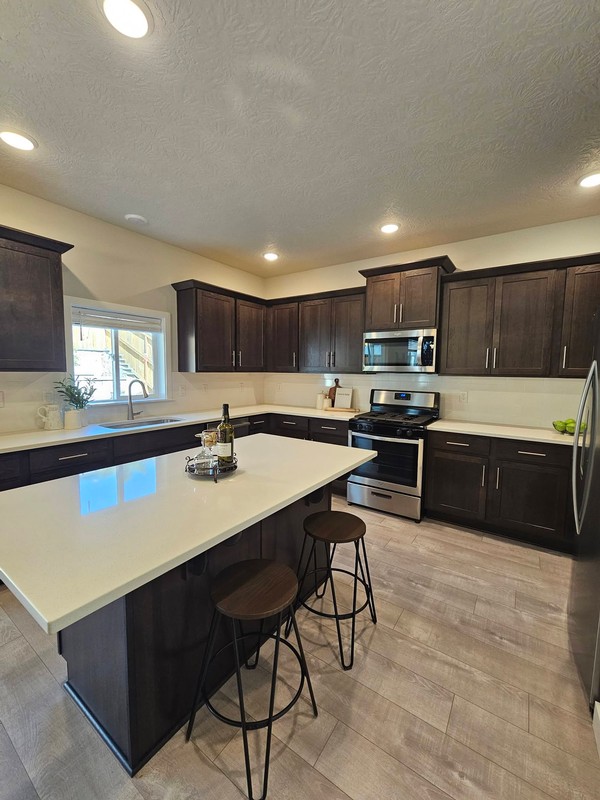 The kitchen has a polished, orderly appearance, with countertops, cabinetry, appliances, island surfaces, and flooring presented cleanly after the residential deep cleaning.